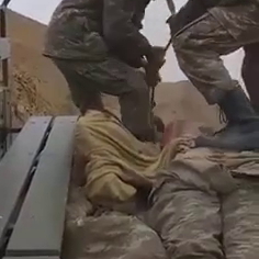 An Armenian soldier walks on the bodies of Azeri soldiers in a van.